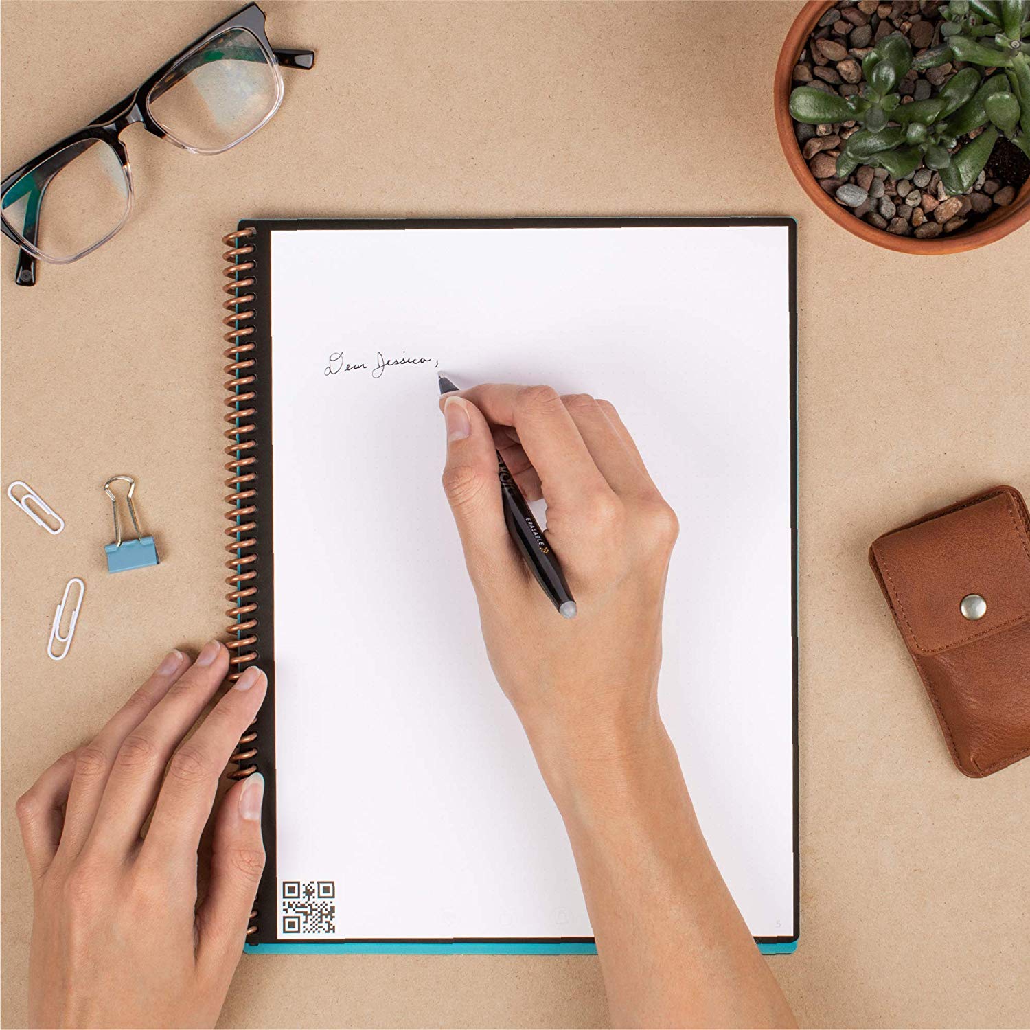 someone writes on the Rocketbook Smart Reusable Notebook