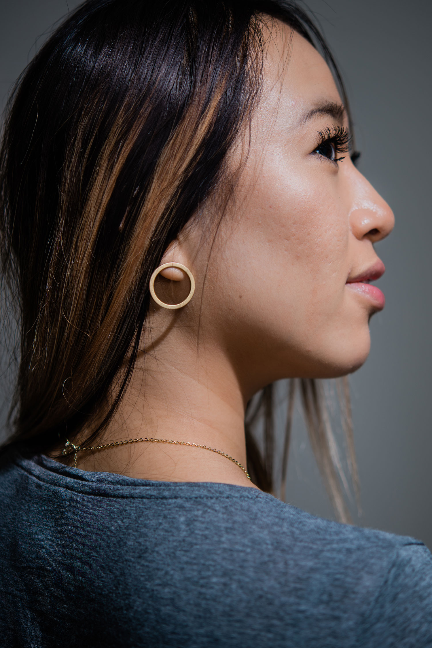 Geneve Lau (COM '21) shows off a small gold chunky hoop earring