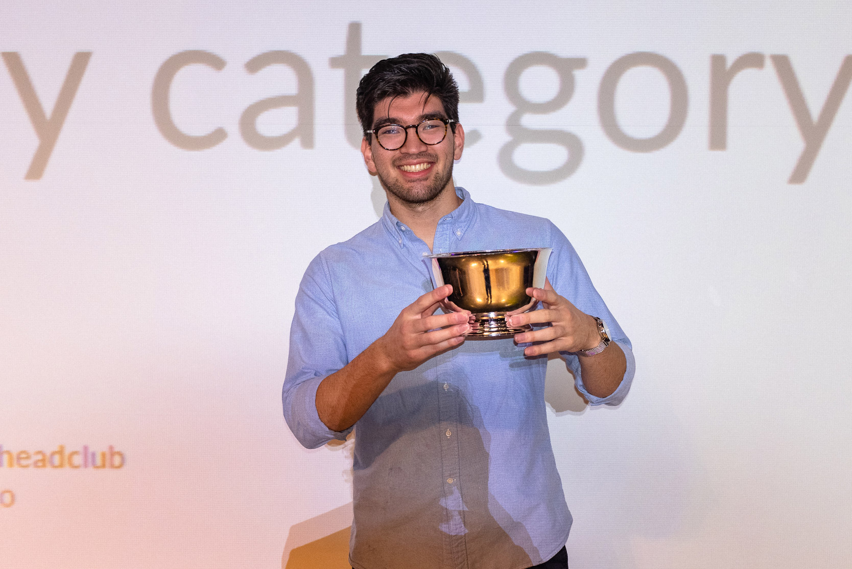 Alex Chapman (COM’20) holds a hatch award on stage