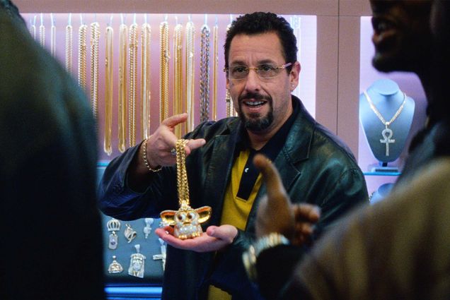 Adam Sandler’s character holds up a bedazzled Furby