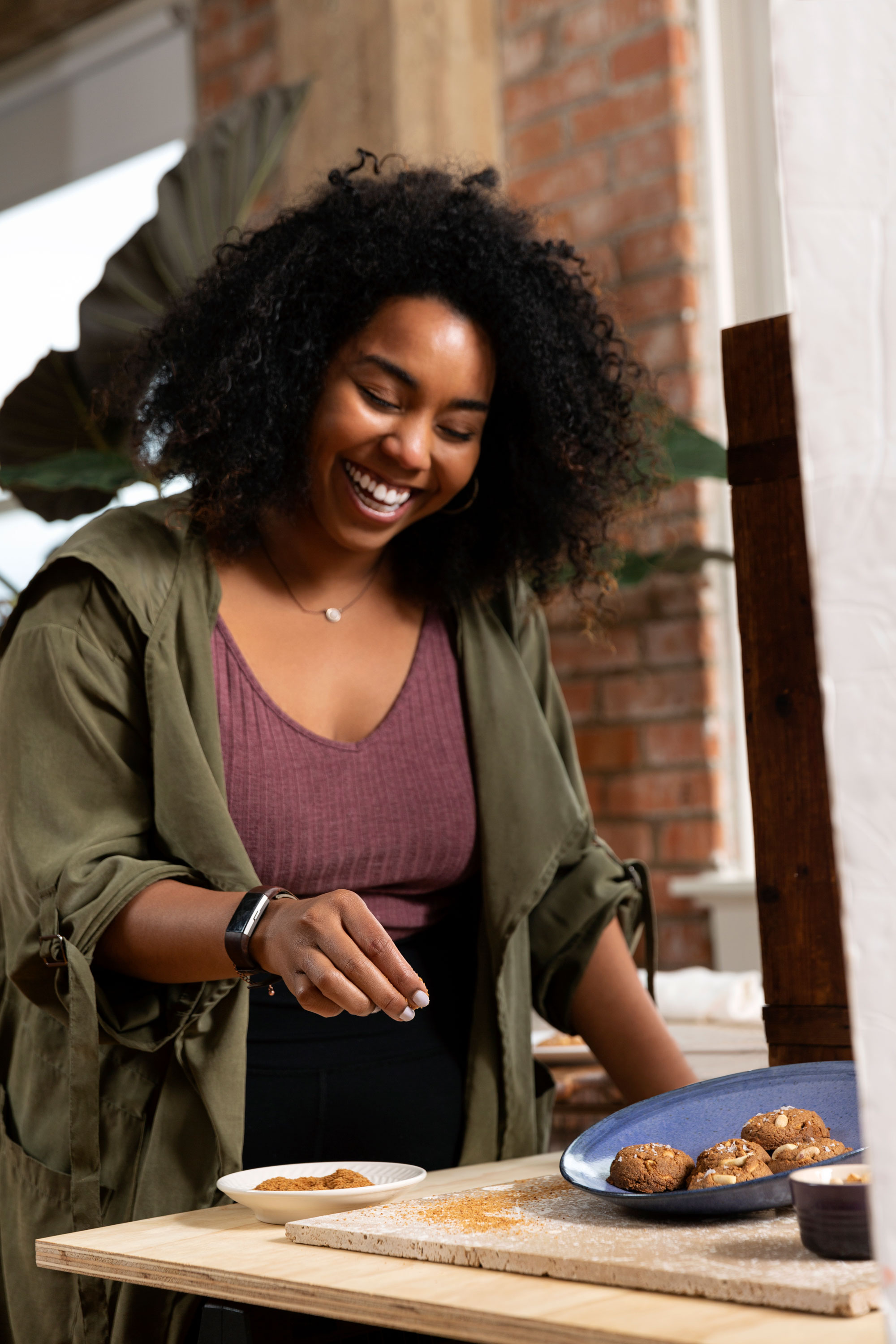 Alum Jerrelle Guy laughs while she sprinkles cookies with sugar