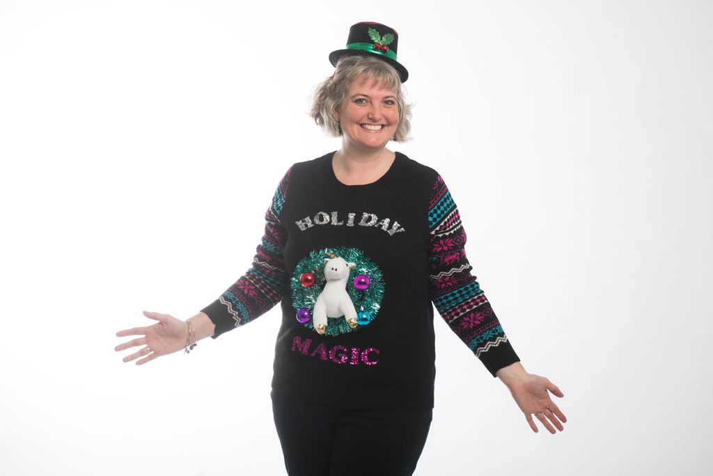 Suzanne Bagnera wears an ugly sweater of a unicorn inside a wreath