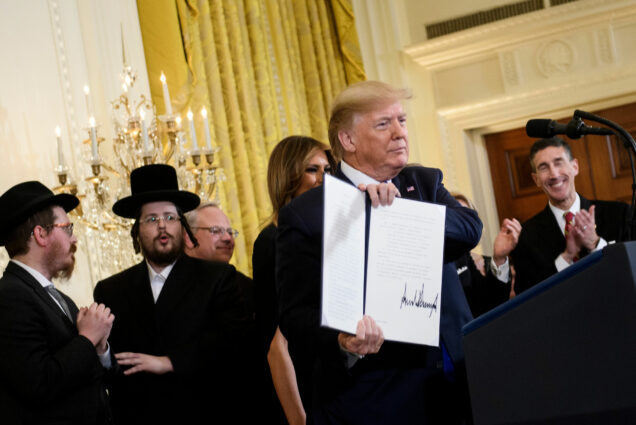 US President Donald Trump shows an executive order regarding anti-semitism during a Hanukkah reception in the East Room of the White House December 11, 2019, in Washington, DC.