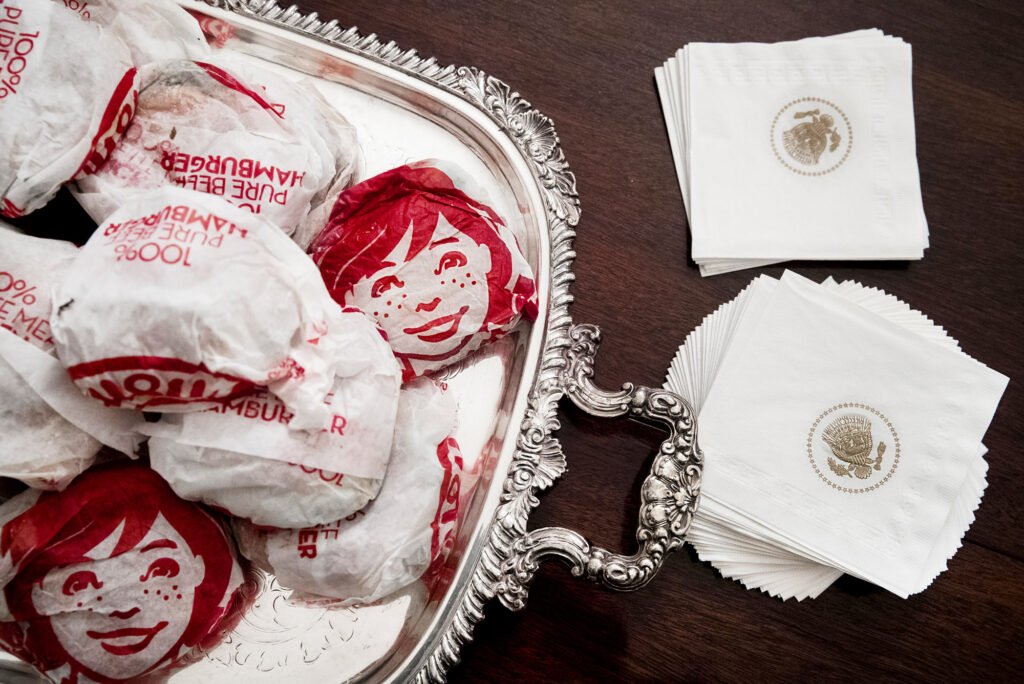 a pile of Wendy's burgers next to white house napkins