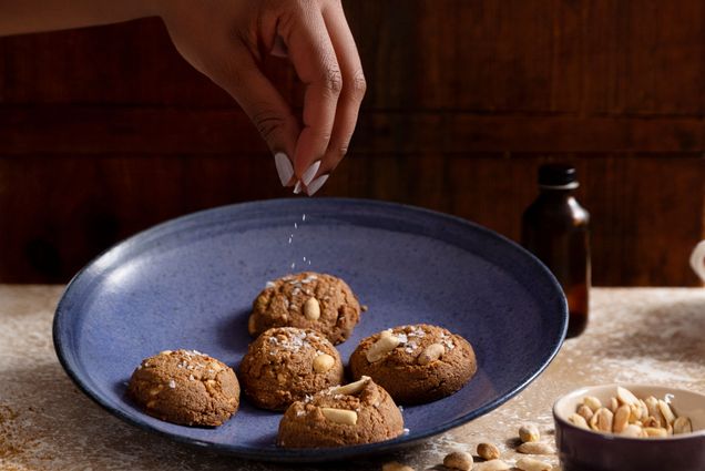 Jerrelle Guy's hand sprinkles a plate of cookies with sugar