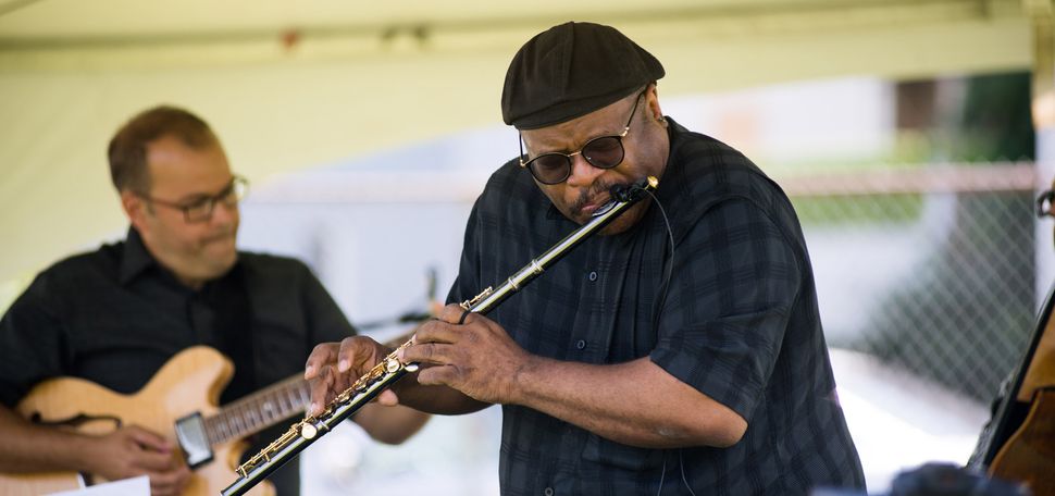 A photo of Lance Martin playing the flute on stage.