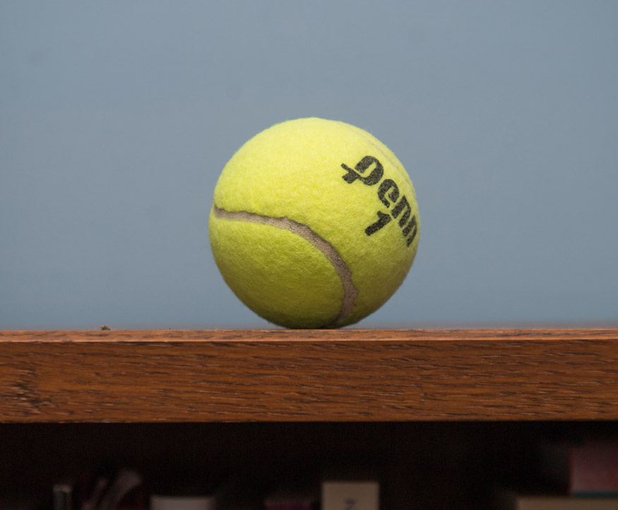 A photo of a yellow tennis ball with the words Penn 1 visible on it