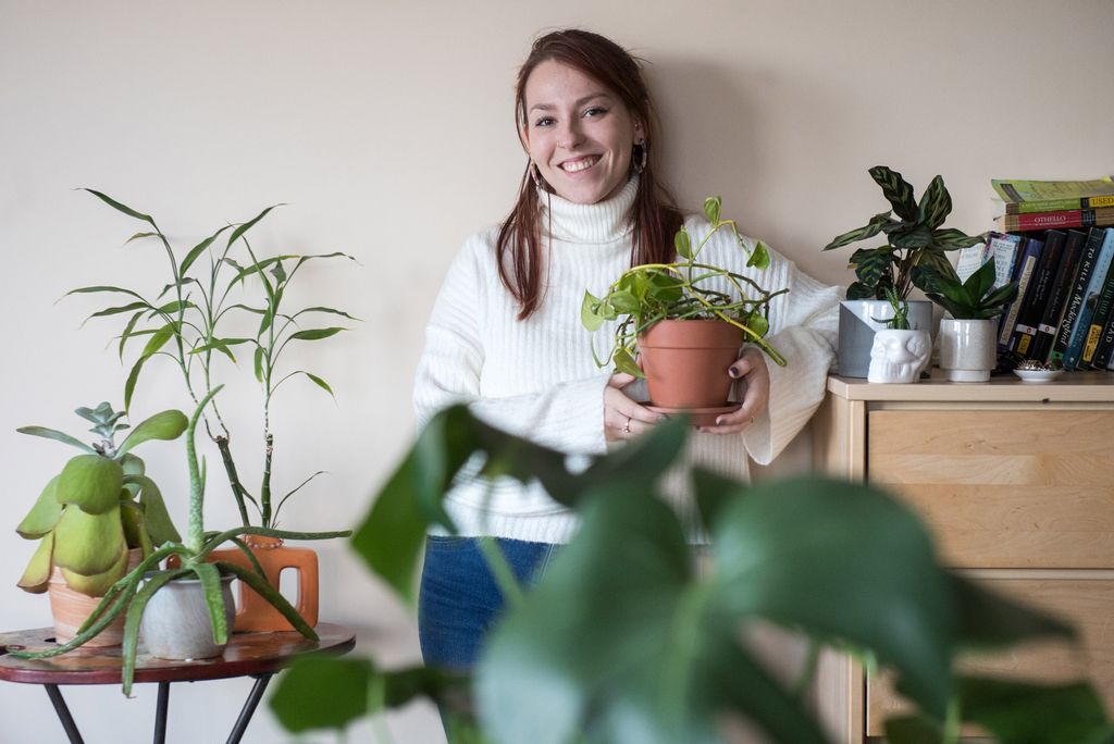 Kate Pluister poses in her dorm room with a variety of plants