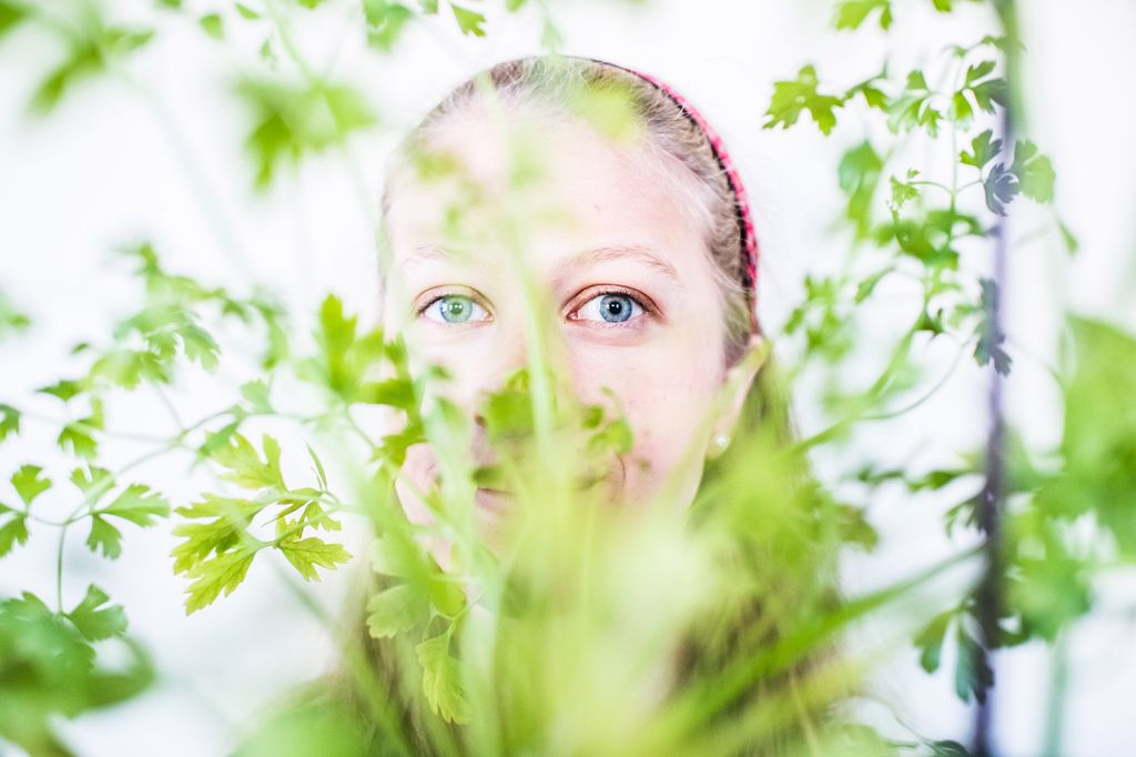 Elsa Brenner (CAS’21) peers out from behind a plant