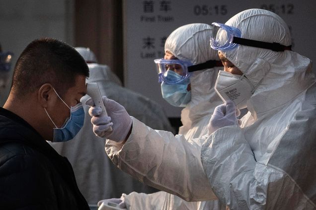 Chinese health workers in white suits, check the temperatures of Chinese residents