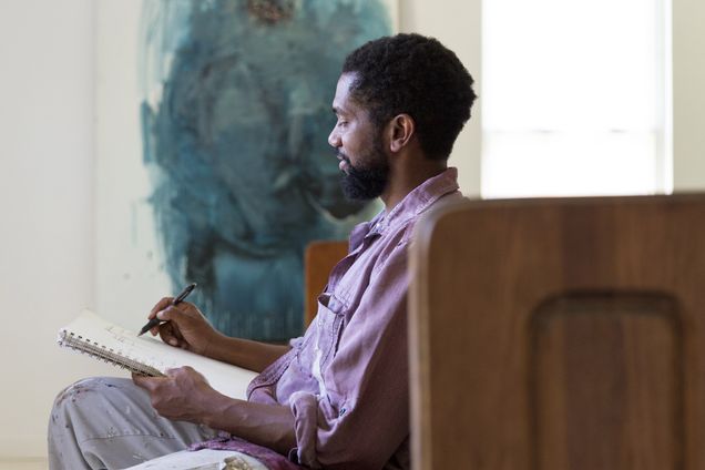 A portrait of painter Sedrick Huckaby sitting on a bench and sketching.