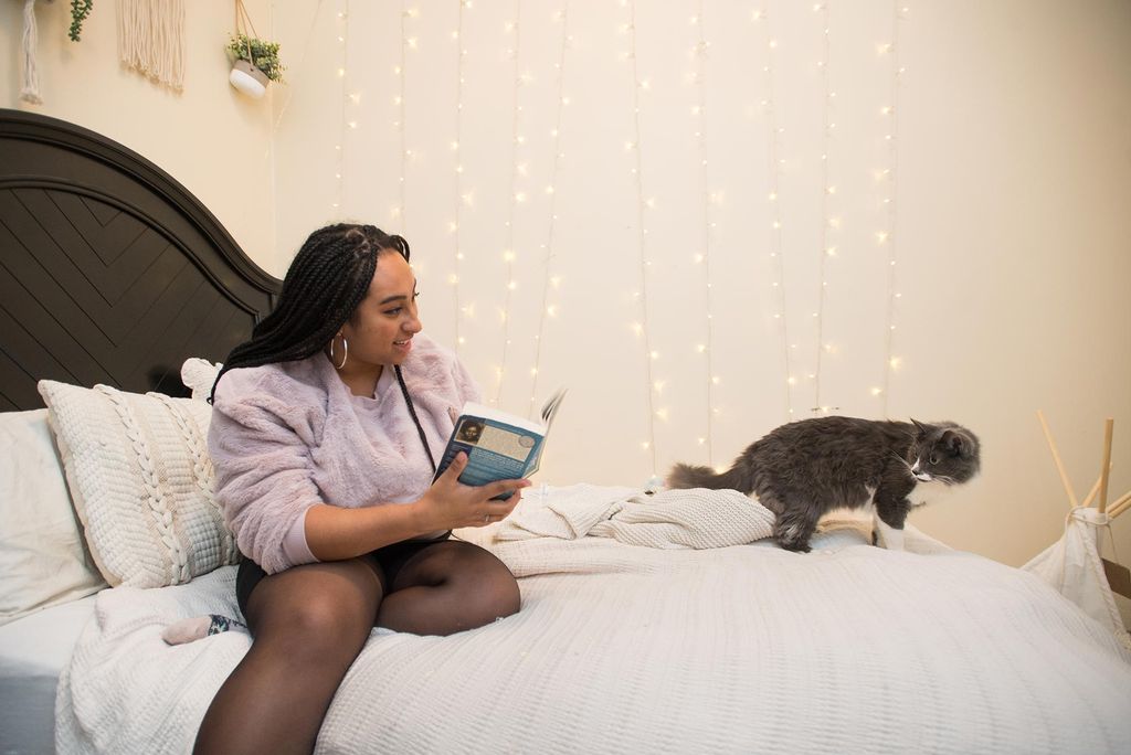 Toria Rainey plays on her bed with her kitten Billie