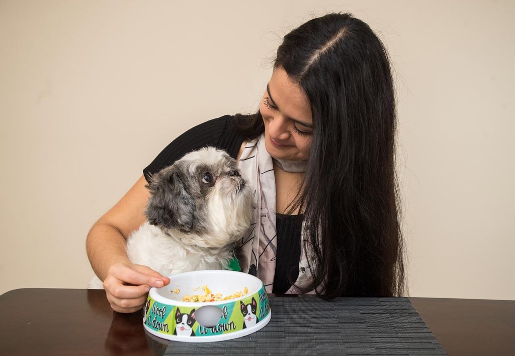 Tania Mazariego feeds breakfast to her Shih Tzu named Java.