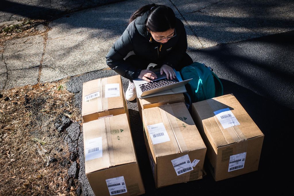 A photo of Huilin Fang organizing boxes that will be shipped to China
