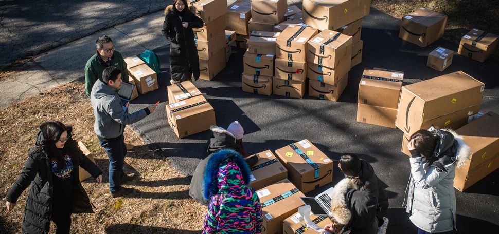 A photo of Shishong Chen, a law student from China, and other students organizing boxes that will be shipped to China.