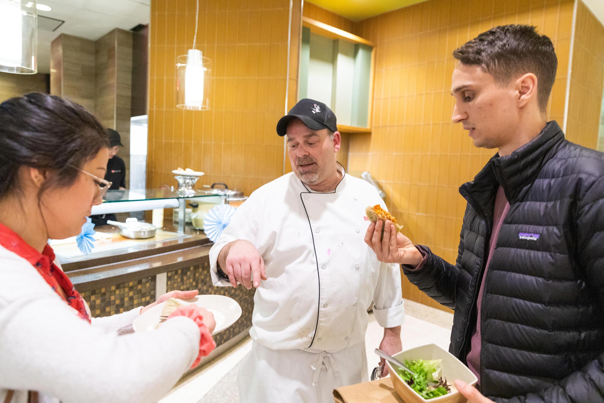 A photo of Liza Stone and Matt Ellison, employees and cooks at Mei Mei, taste BU's rendition of their recipes along with Armand Toutaint, Residential Executive Chef.