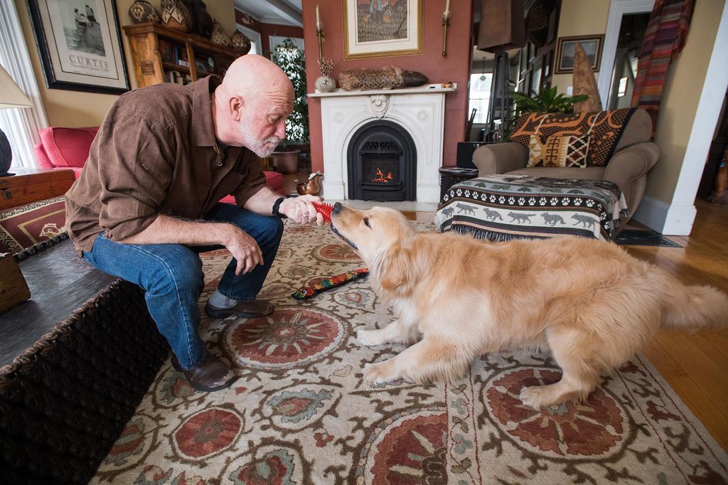 Bob Loftis Plays with his dog Diego in their living room