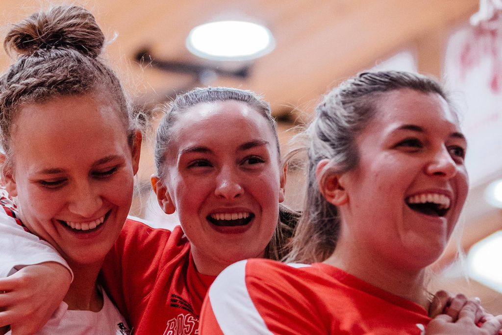 A photo of Nia Irving (Sargent’20) (from left), Liz Shean (COM’23), and Vanessa Edgehill (COM’20) after BU’s 46-44 quarterfinals victory over American University March 9