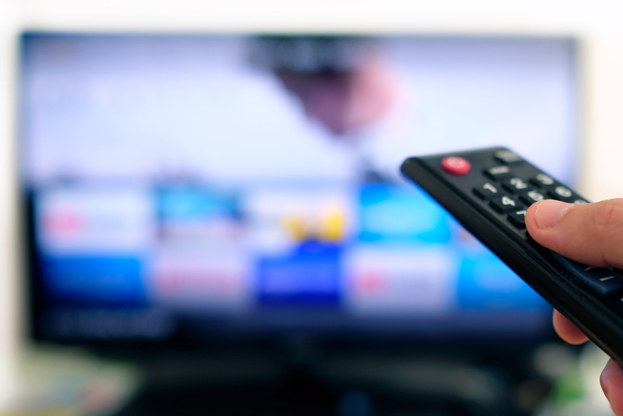 A photo of someone pointing a remote at a television screen