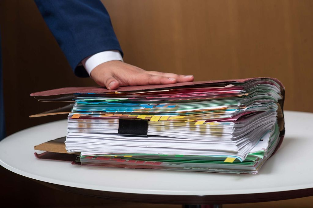 Boston University Immigration Law student Luis Guerrero holds his hand on the paperwork file for maria's asylum hearing