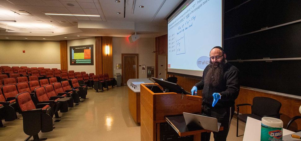 Senior Lecturer in Chemistry Binyomin Abrams gives a remote lecture using a laptop and his smart-podium at Boston University.