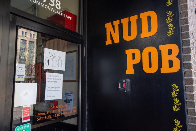 The front of NUD POB Thai cuisine on Comm Ave with a sign that says “We’re opened. Take out, call in, online ordering and delivery only. Our apologies for the inconvenience. Thank you” taken on March 18, 2020.