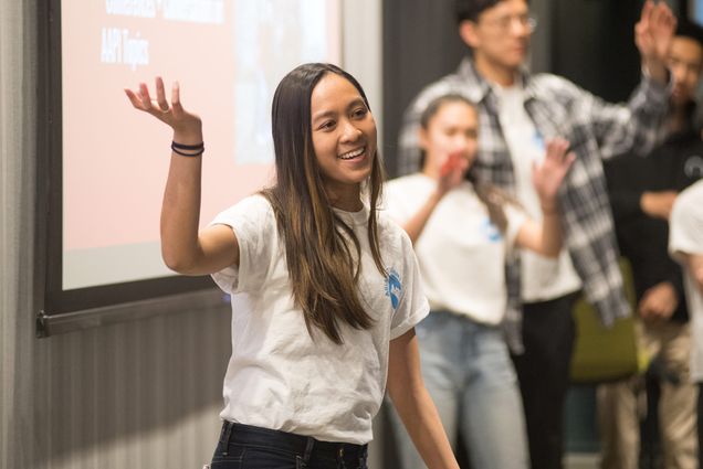 Valerie Nam, President of BU’s Asian Student Union, speaks in front of a projector screen.