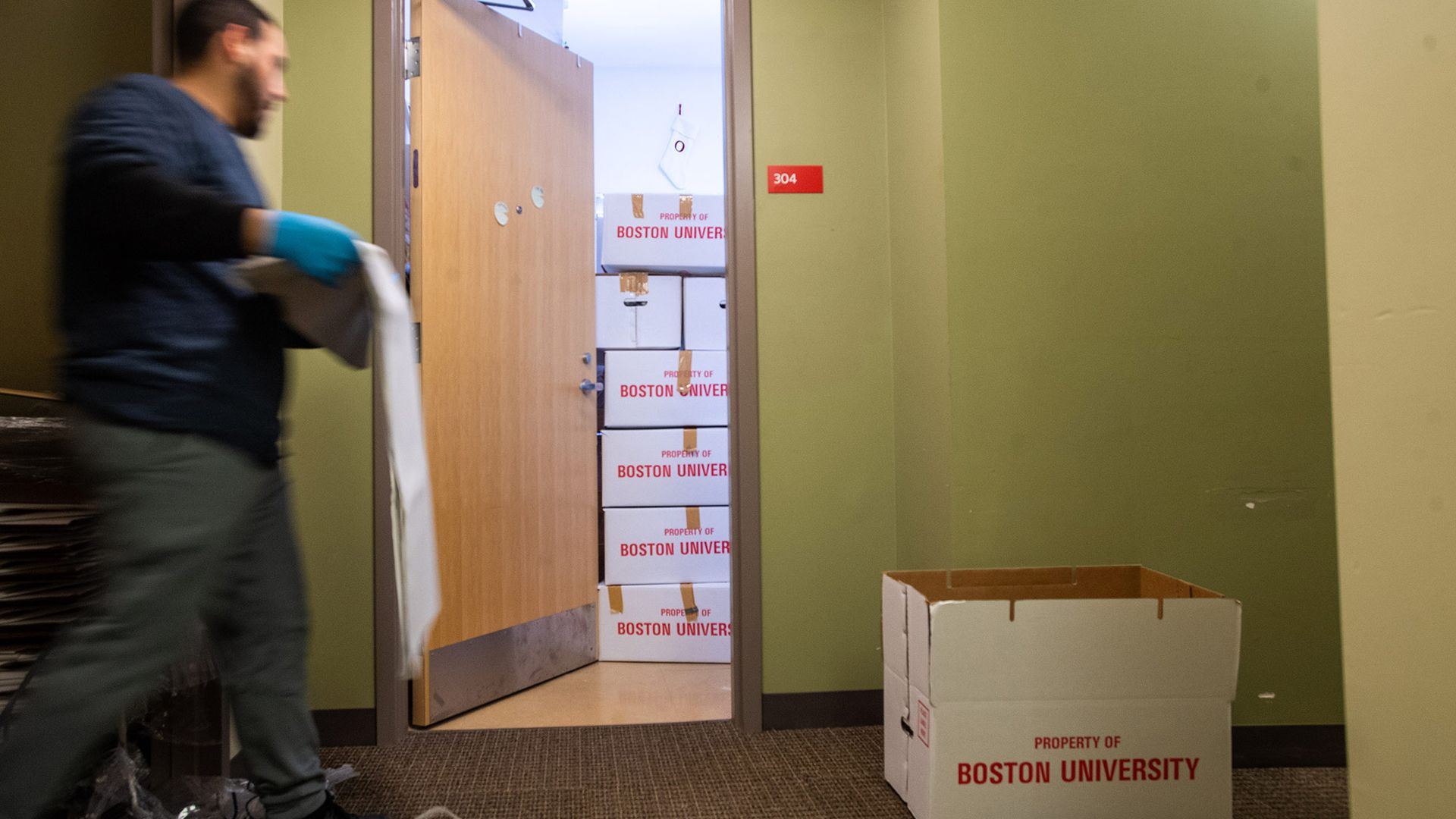 Photo of a worker from Piece by Piece Moving Company emptying out a room at Riverway House on the Fenway Campus in late March. The students who left behind belongings were able to use an app to clarify which belongings they wanted stored, saved, or thrown out. 