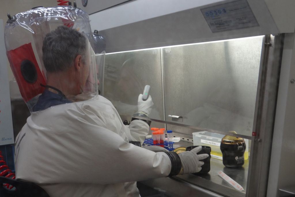 NEIDL microbiologists Robert Davey and JJ Patten purify a batch of the novel coronavirus inside a BSL-4 laboratory.