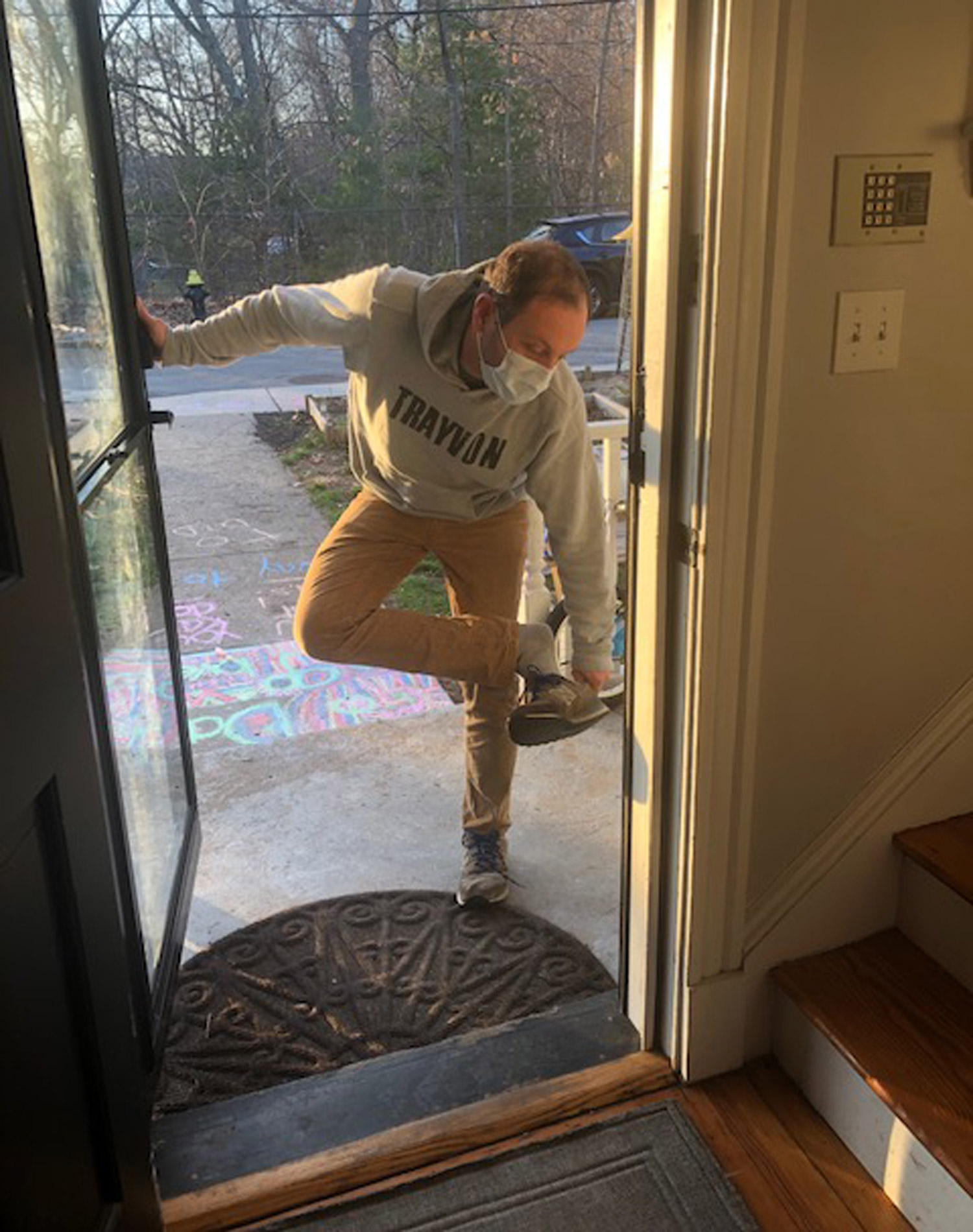 A photo of Joshua Barocas removing his shoes before entering his home after treating COVID-19 patients.
