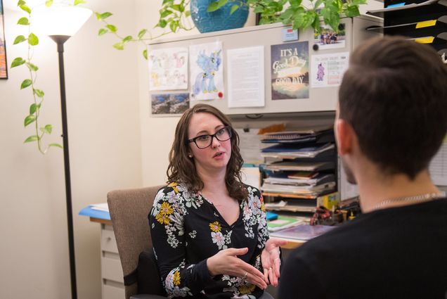 Photo of CAS academic advisor Taryn Andrea meeting with a student in her 100 Bay State Rd office in February of 2018. The back of the student's head is seen on the right in the foreground.