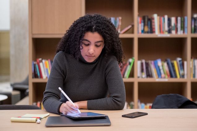 Image of Rana Boustany (ENG’21), who goes over her computer science class notes in the new Howard Thurman Center January 30, 2020. She is dressed in a gray sweater and uses a stylus on a tablet.