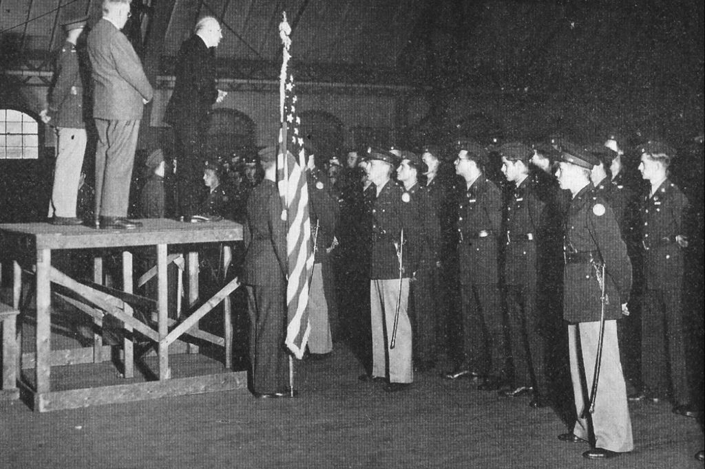 Black and white image of Marsh delivering a speech to students in military dress, 1942. Photo from Bostonia