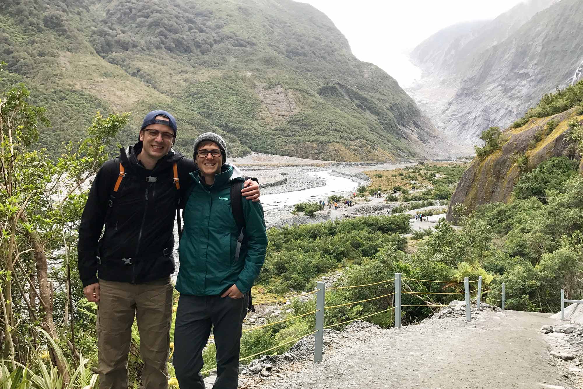 A photo of siblings Andrew and Aiken Bottoms with a mountain and stream in the background.