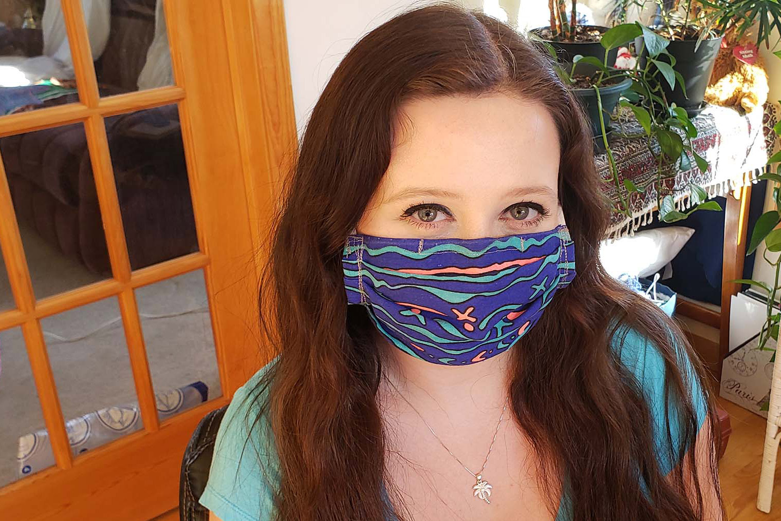 Image of Laura Stursberg with a dark blue, hand-sewn face mask on in her home in Connecticut.