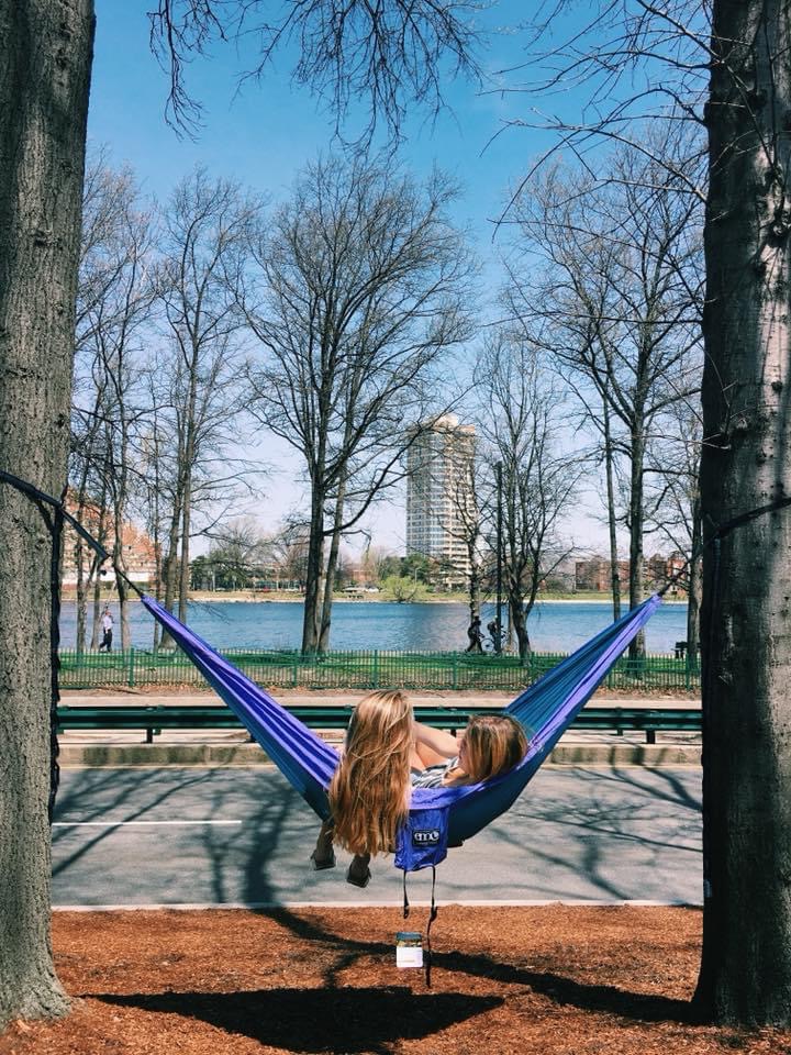 Photo of Anna Doherty (COM’20) and a friend in a hammock near the Charles River.