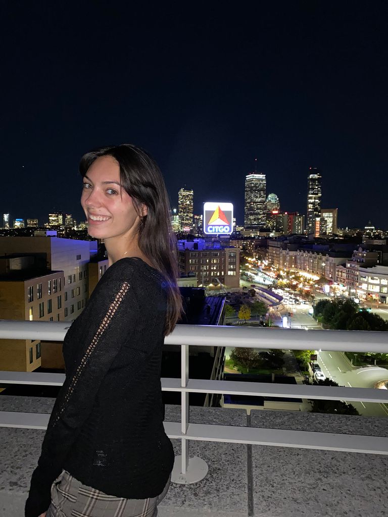 Photo of Laura Jeshiva (COM’20) with Citgo sign and Boston city skyline in the background.