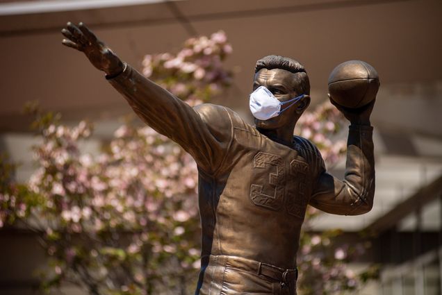 The Harry Agganis statue outside Agganis Arena at Boston University wearing a medical facemask.