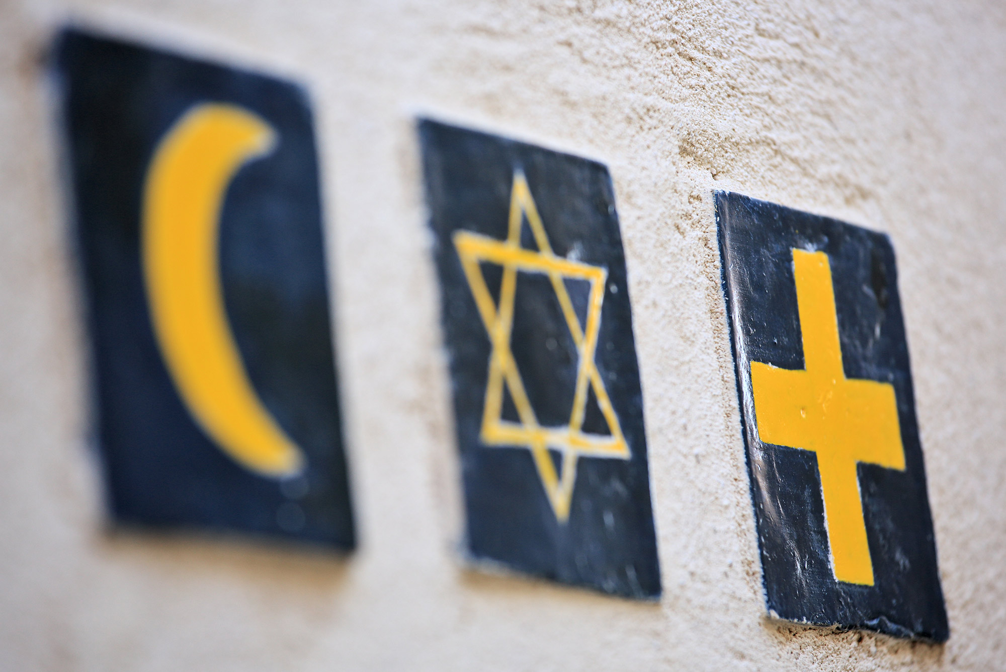 An image of an Islam crescent, Star of David, and Christian cross