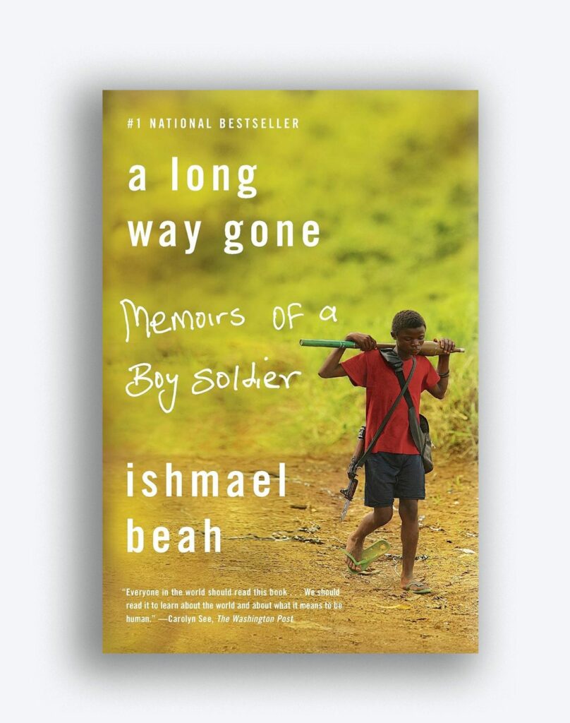 Book cover for "a long way gone" by Ishmael beah. Cover pictures a young boy with a gun carried behind his soldiers walking on a dirt road.