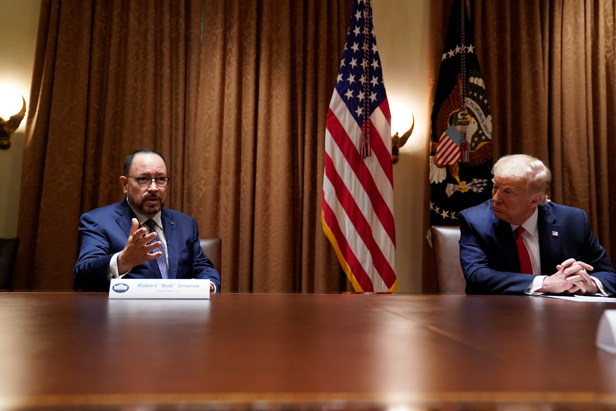 A photo of Goya Foods CEO Robert Unanue and President Donald Trump sitting at a conference table