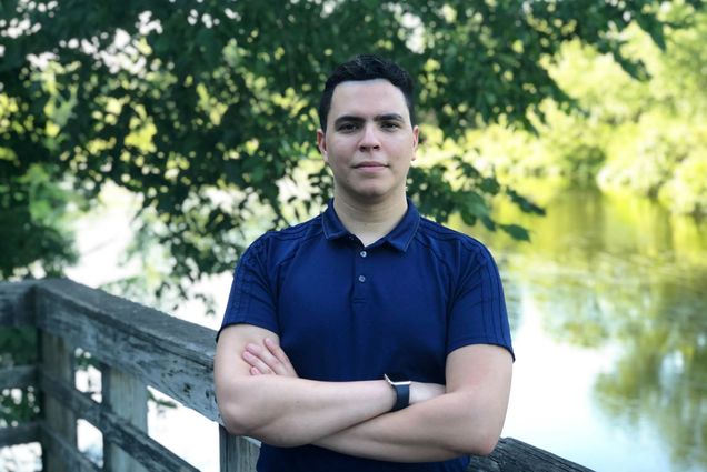 A portrait photo of Santiago Gomez standing with his arms crossed