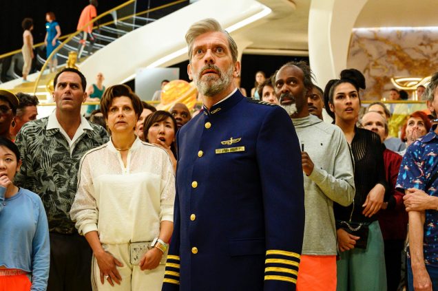 Shot from the sci/fi comedy Avenue 5 featuring Hugh Laurie dressed in a blue caption's uniform in the front center. 