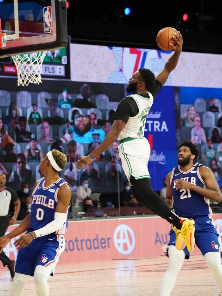 Photo of Jaylen Brown of the Boston Celtics dunks while Philadelphia 76ers players Joel Embiid and Josh Richardson look on. The Celtics swept the Sixers and will play the defending NBA Champions, the Toronto Raptors, in the Eastern Conference Semifinals. 