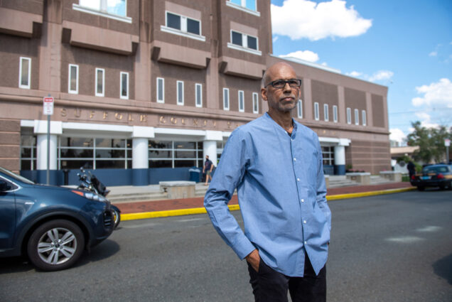 A photo of André de Quadros standing in front of Suffolk County House of Corrections