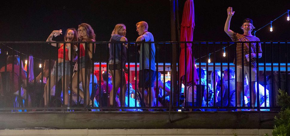 Patrons without facemasks on the rooftop bar at The Bear Trap on The Strip, Tuscaloosa, Alabama