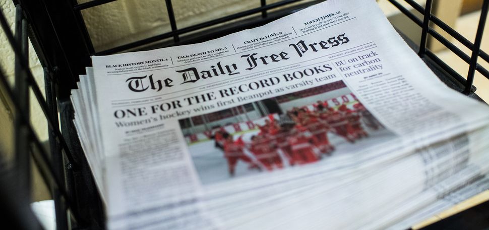 Photo of a stack of The Daily Free Press newspapers stacked in COM building on Friday, February 15, 2019. The headline reads "One for the Record Books" and has an image of BU Hockey team celebrating.