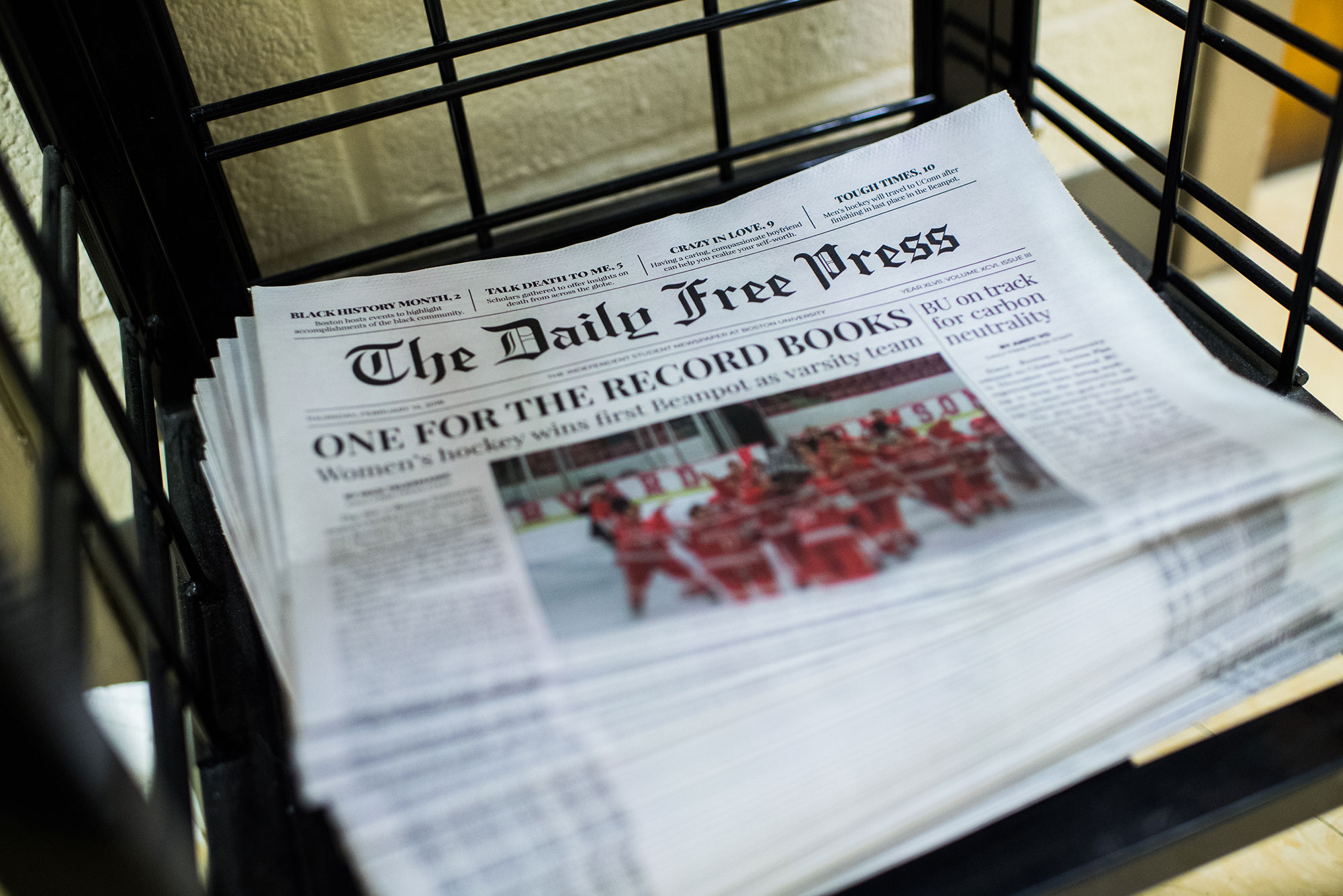 Photo of a stack of The Daily Free Press newspapers stacked in COM building on Friday, February 15, 2019. The headline reads "One for the Record Books" and has an image of BU Hockey team celebrating.