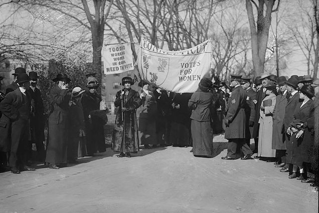 A photo of suffragettes holding a sign that reads "Votes for Women"