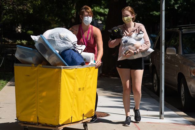 Elina Brooks (ENG’24), right, moves into Kilachand Hall with the help of her mom M.J. Brooks August 17. The two traveled from Annapolis. Both women wear masks and M.J. Brooks pushes a yellow cart of belongings while Brooks carries something.